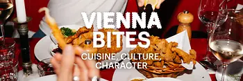 A lively dining table scene featuring people sharing Viennese dishes, including fried foods, potato salad, and wine. Hands reach in to squeeze lemon over the food. The text ‘Vienna Bites – Cuisine, Culture, Character’ appears over the image.