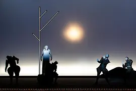 Opera scene with several performers against a minimalist stage set with a bright light source.