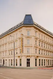 Helles Eckgebäude mit historischer Fassade, modernem Dachaufbau und vertikalem „The Companion“-Schriftzug an einer ruhigen Straßenkreuzung.