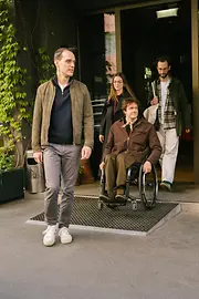 Several guests are leaving magdas Lokal, including a man using a wheelchair on a ramp at the entrance. The image shows accessible access to the venue.