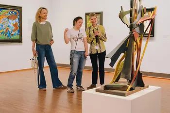 Several people are standing in the Albertina in front of a sculpture and viewing it together. The image shows accessible access to cultural experiences.