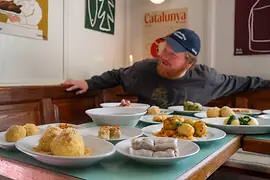 Lukas Mraz bei Tisch mitten in der Wiener Knödelszene