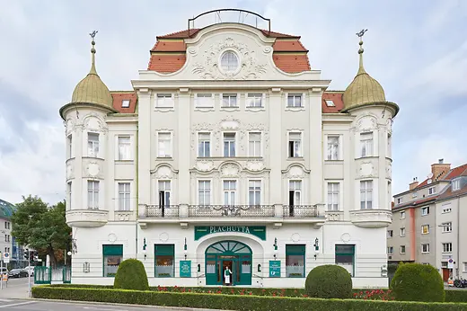 Façade of the Plachutta flagship restaurant in Hietzing with ornate architecture and landscaped front garden.