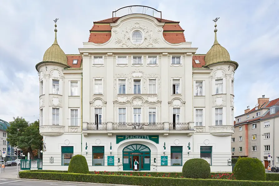 Façade of the Plachutta flagship restaurant in Hietzing with ornate architecture and landscaped front garden.