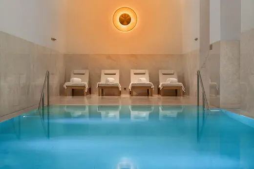 Spa area at Almanac Palais Vienna with a heated pool and four loungers.