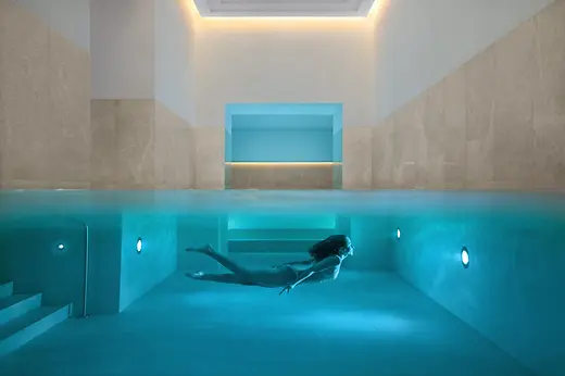 Indoor pool at Almanac Palais Vienna with a swimmer.