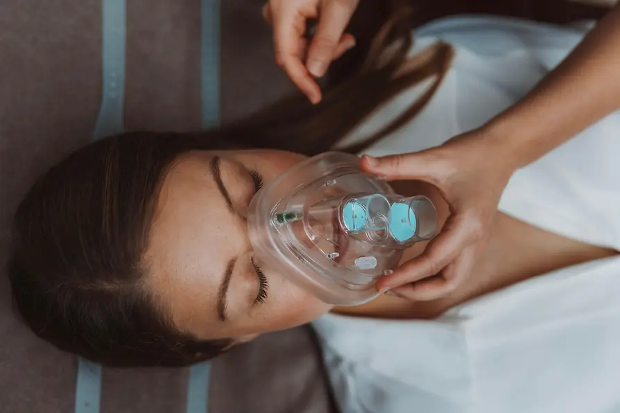 Woman wearing a breathing mask during a health treatment at BIOGENA.