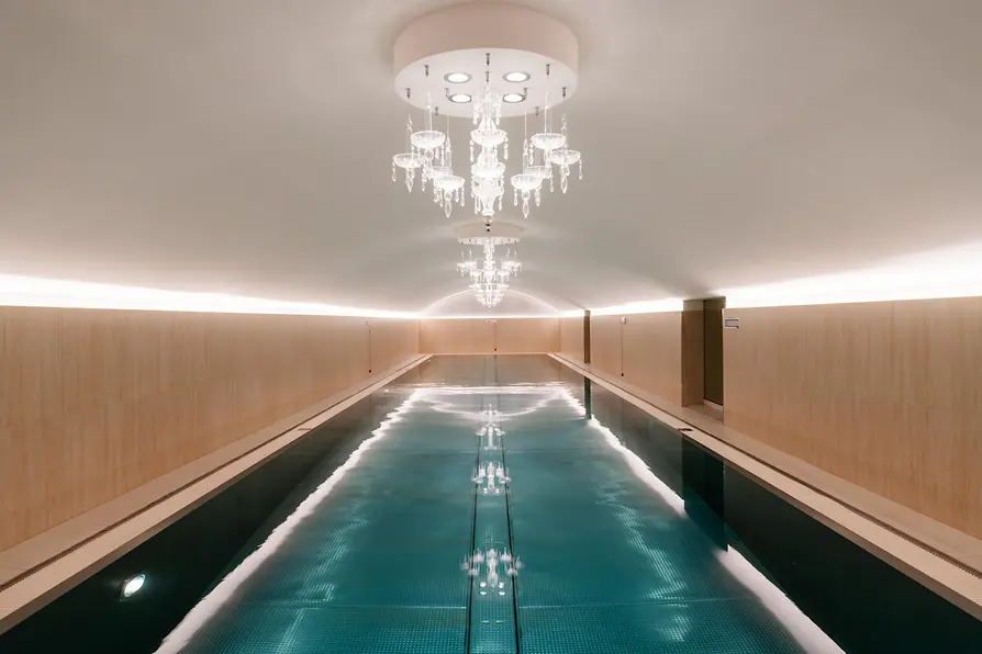 Indoor pool at Sans Souci Spa with crystal chandeliers and illuminated water.