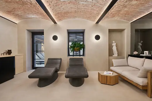 Relaxation room at The Amauris spa with loungers, a sofa and a marble sculpture.