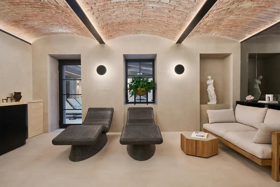 Relaxation room at The Amauris spa with loungers, a sofa and a marble sculpture.