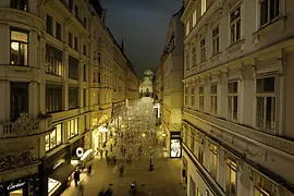People taking an evening stroll on the atmospherically lit Kohlmarkt 