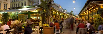 Bustling scene in the pubs and cafes at Naschmarkt, exterior shot with people 