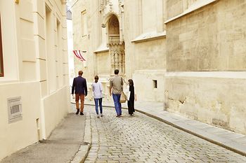 Vier Menschen spazieren durch die Altstadt von Wien 