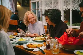 © WienTourismus/Mafalda Rakoš Gäste amüsieren sich und essen Wiener Schnitzel beim Heurigen