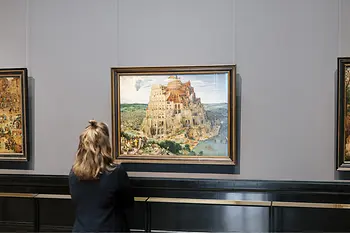 Visitor standing in front of the painting "Tower of Babel" by Pieter Bruegel at the Museum of Fine Arts in Vienna