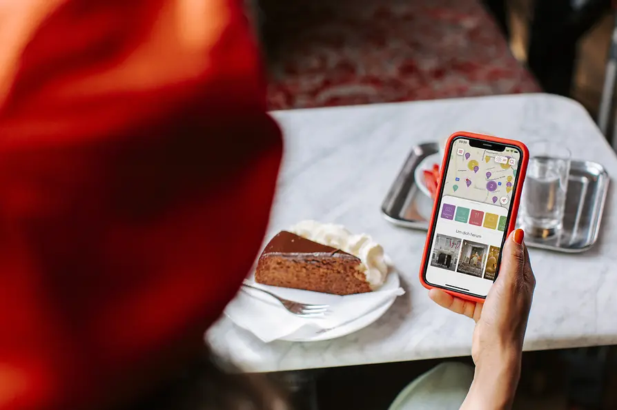 Frau mit Handy bei einer Sachertorte