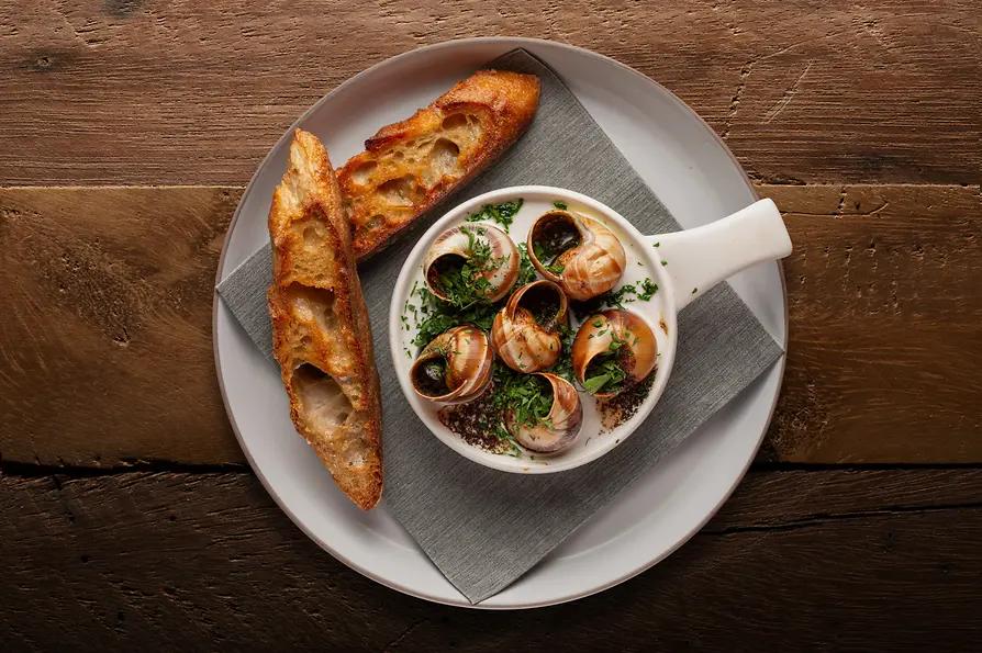 Bernhard Buzin Ma Belle Bistro & Bar, Gumpendorfer Straße 16. Innenansicht. Teller mit Schnecken und Brot.