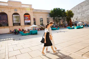 A couple walks in the inner courtyard of the Museumsquartier