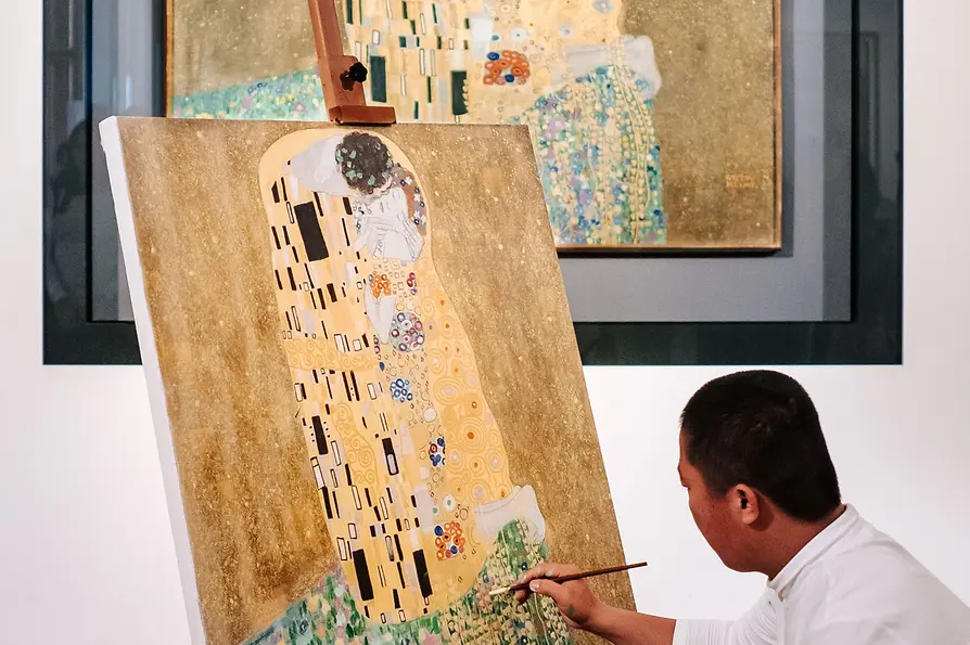 WienTourismus/ Paul Bauer Der Kopist Xiucun Gan vor Klimts "Der Kuss"