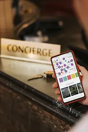 A man is standing in front of reception, with the ivie app open on his cell phone