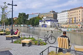 Menschen am Donaukanal. Blick auf Otto Wagner Schützenhaus.