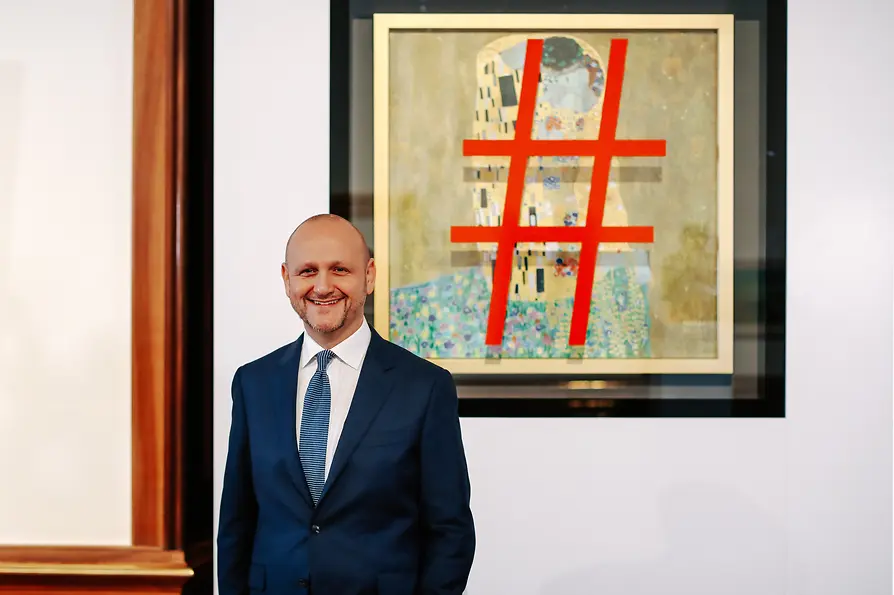 WienTourismus / Paul Bauer Tourismusdirektor Norbert Kettner vor der Replik mit Klimts „Kuss“ samt Hashtag.