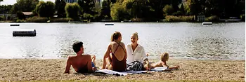 Strandbad Gänsehäufel an der Alten Donau: Ein Mann, zwei Frauen und ein Kind am Strand