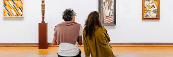 Museumsbesuch Albertina, zwei Menschen sitzen auf einer Bank und betrachten Kunst