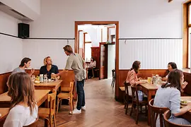 Interior view of the Brösl restaurant in the Stuwerviertel, guests being served