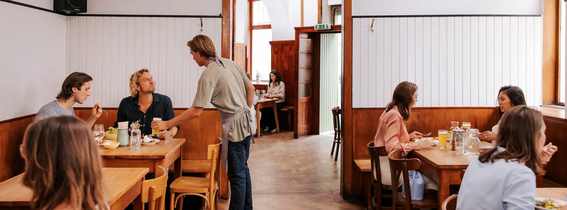 Interior view of the Brösl restaurant in the Stuwerviertel, guests being served