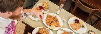 Two people at a table with numerous Wiener schnitzels