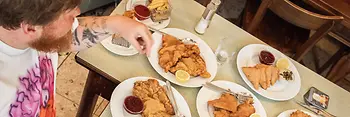 Two people at a table with numerous Wiener schnitzels