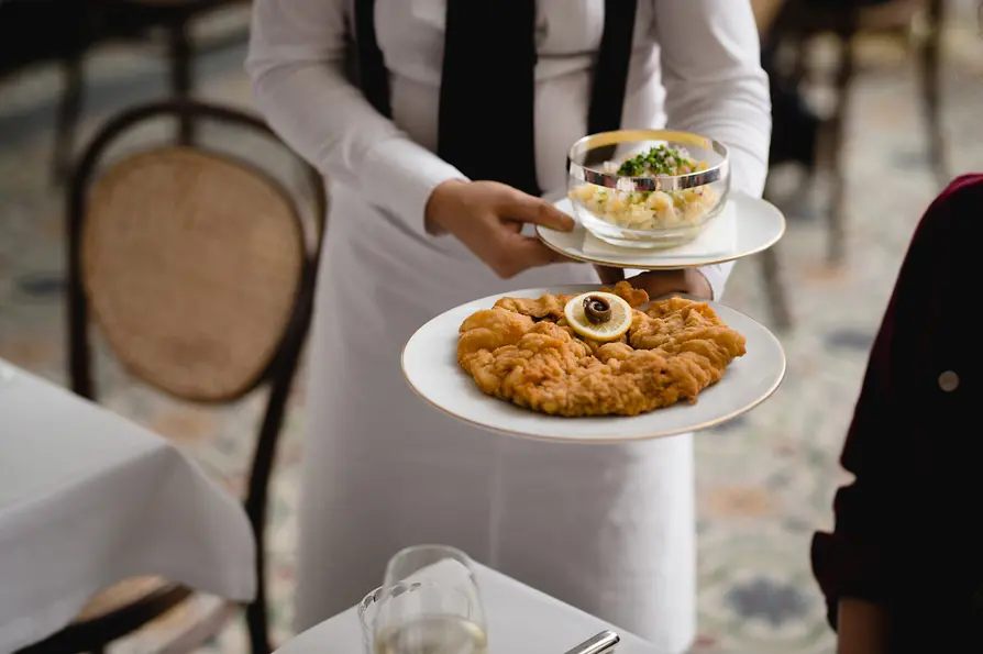 Meissl & Schadn: Waiter serves Wiener Schnitzel