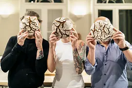Kruste&Krume: Backworkshop, Teilnehmer halten sich Brotlaibe vor ihre Gesichter