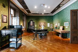 Green salon in the Strauss apartment with music stand, piano and violin case