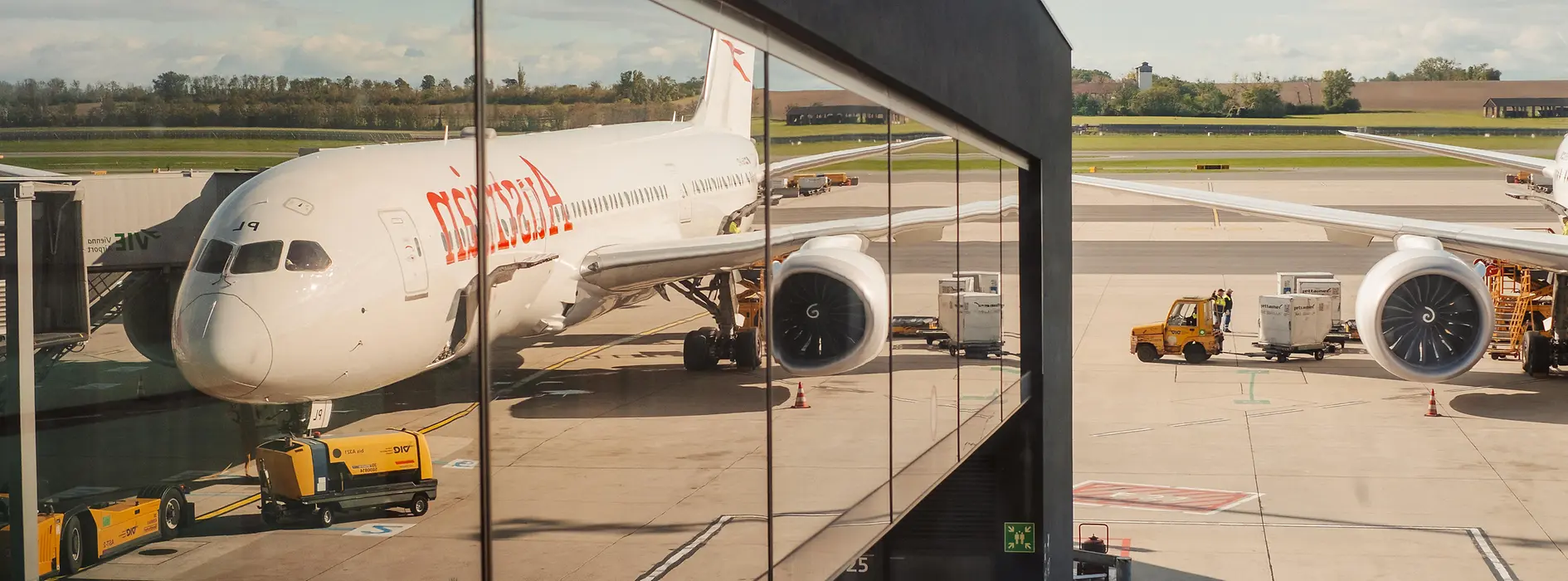 Airplane at Vienna Airport reflected in the glass facade of the terminal