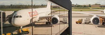 Airplane at Vienna Airport reflected in the glass facade of the terminal