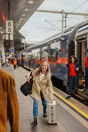 Personen am Bahnhof, die aus dem Zug steigen