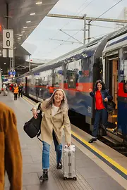 Personen am Bahnhof, die aus dem Zug steigen