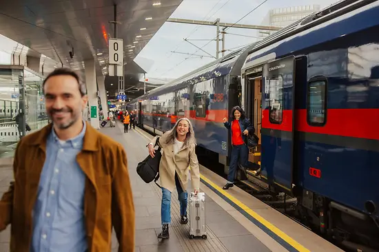 Personen am Bahnhof, die aus dem Zug steigen