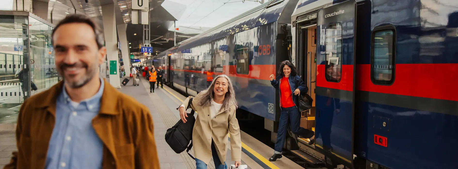 Personen am Bahnhof, die aus dem Zug steigen