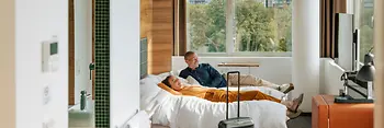 Hotel Daniel, room with a view of the greenery, 2 people lying on the bed