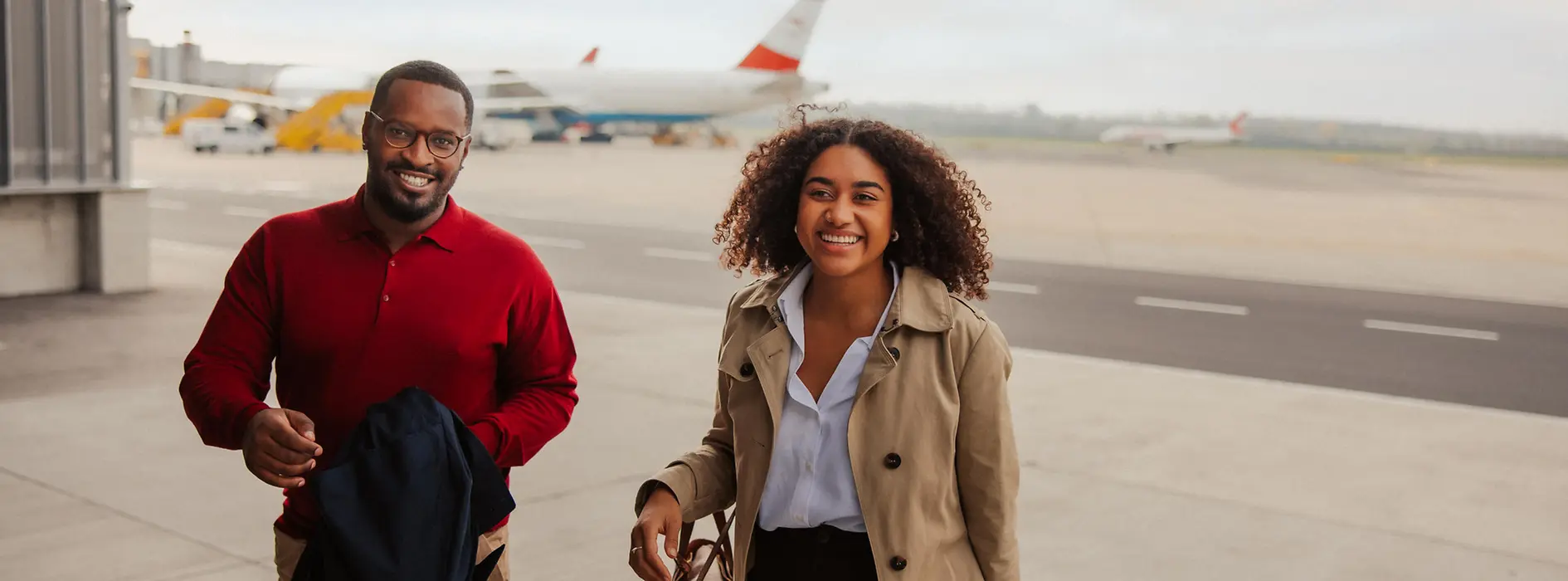 Two people at the airport, an Austrian Airlines aircraft in the background