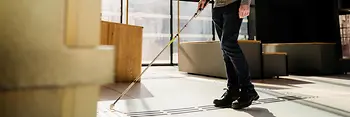 Blinde Person nutzt taktiles Bodenleitsystem.