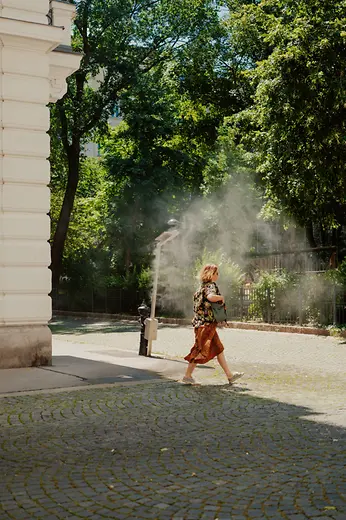 Female pedestrian with mist shower in the Piaristenviertel